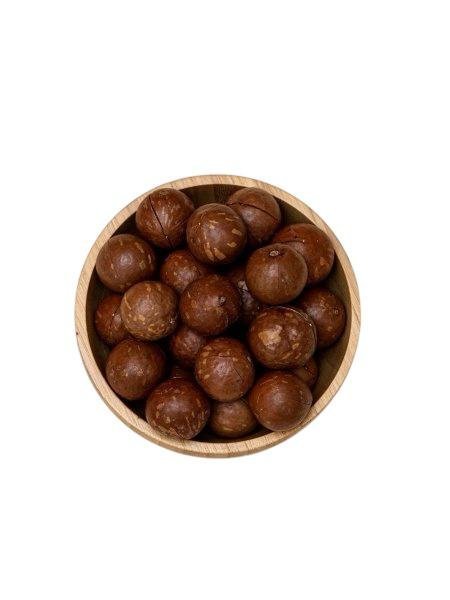 ماكاديميا (Macadamia) - مكسرات الماكاديميا بقشرتها الصلبة في وعاء خشبي